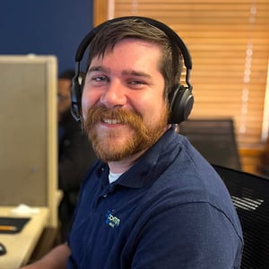 Dexcomm agent smiling and answering a customer service call using a headset in office