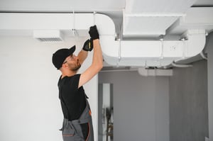 HVAC technician working on air ducts