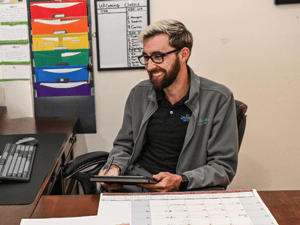 Dexcomm Call Center Employee Smiling and Sitting at Desk