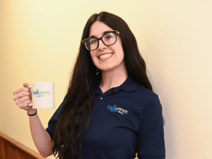 Dexcomm Employee Holding a Mug and Smiling